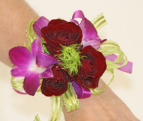 Red spray rose and fuchsia dendrobium orchid wrist corsage from The Posie Shoppe in Prineville, OR